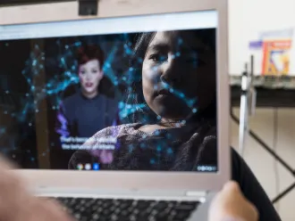 A child's face is reflected in a tablet screen.