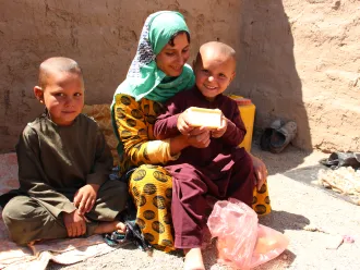 The picture shows a family who has received soap distribution in Herat IDP sites