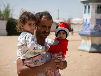 After receiving the food supplements for his 2 malnourished daughter, Moharram Al-Oshari is taking his daughters, Bulqis and Arwa back to their tent.