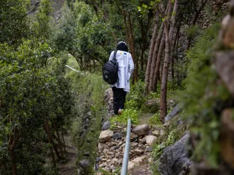 Saba walks up a stone path.