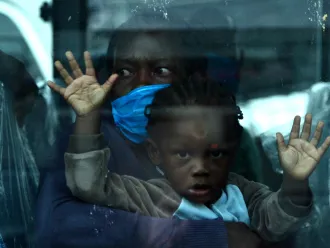 A mother and child are seen onboard a bus as they wait to be taken into quarantine.