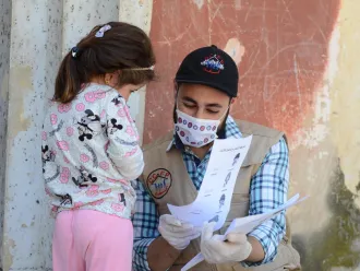 A UNICEF volunteer meets with a child in Syria.