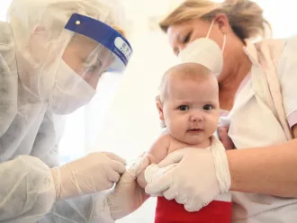 A baby receives a vaccination injection.