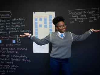 Sebabatso stands in front of her science class.