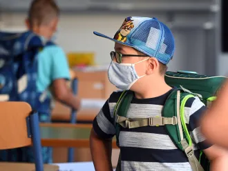 A student with a face mask stands in a classroom at the Petri primary school in Dortmund, western Germany.