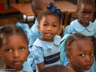 On 20 June 2023, students stand together during a visit by UNICEF Executive Director Catherine Russell and World Food Programme (WFP) Executive Director Cindy McCain to a UNICEF- and WFP-supported school in Port-au-Prince, Haiti.