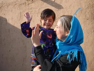Sam Mort, Chief of Communication for UNICEF Afghanistan, holds Parwana who is a young child in her arms.