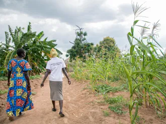 Harriet, a member of the Kilameling Parenting Without Violence group and chats with a para social worker from Save the Children in Kilameling ward, Obongi Town Council, Obongi District.