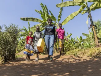 On 17 July 2023, UNICEF Goodwill Ambasador Vanessa Nakate walks with Adele (in pink), Graciella (in black and white stripes) and Bonette in Kigarama Sector, Kirehe District, Eastern Province of Rwanda.