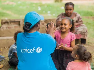 A UNICEF Staff member plays with a child in Sudan. 