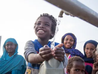 Children collect safe water from a new water station in the village of Gelhanty, Sudan.