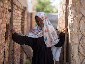 In Sudan, 13-year-old Fiyha smiles at the camera.