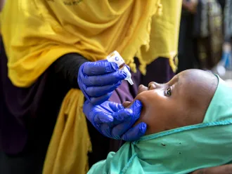 A child in Sudan is receiving a polio vaccination