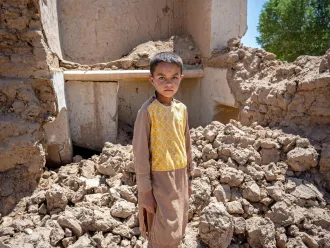 On the 28th May 2024, 9 year old Farzan is photographed in the ruins of his house in Chaghcharan district, Ghor province in western Afghanistan.