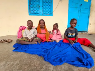 On 1 July 2024, displaced children sit next to their luggage at a school in Gedaref after fleeing Sinja, Sennar state, following the recent clashes.