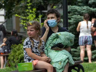 On 8 July 2024 in Kyiv, a child sits on a bench and cries as rescuers, hospital staff and volunteers clear rubble and search for people trapped under debris after an attack that hit Okhmatdyt hospital, Ukraine's largest children's medical centre.