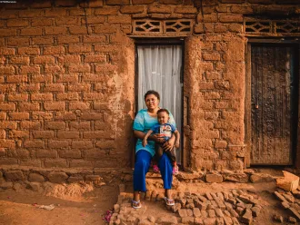 1-year-old Gabriel sits on his mother Sarah’s laps outside their home in Kamanyola, South Kivu province, DR Congo