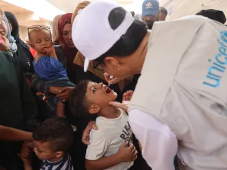 UNICEF Staff adminsters Polio vaccine to a child in Gaza