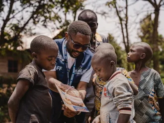 A health worker is seen educating children about mpox symptoms and prevention measures.