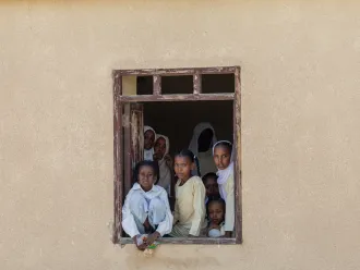 A group of children look out of the window of a school in Port Sudan.