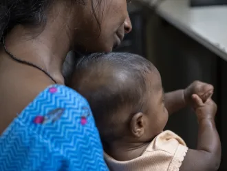 Une mère séropositive tient son bébé dans un centre de dépistage