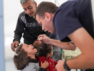 A health worker administers polio vaccine to a child in Gaza