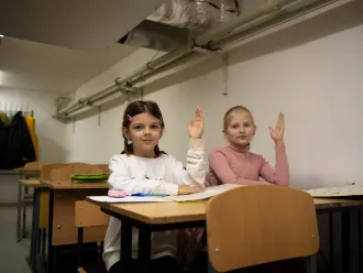 Fourth-grade students attend a lesson in a basement classroom.