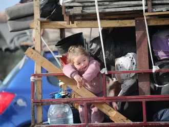 A child looks on as she returns back to her home in Gaza