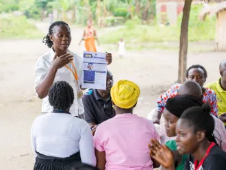 In a community outreach event, Ms. Mbambu Agnes, a Senior Health Educator from Kasese District, educates residents of Kamukumbi Mughongo Village.