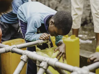 A child fills bucket with clean water in DR Congo