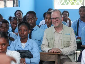 UNICEF Deputy Executive Director Ted Chaiban sits in a classroom with students in a school in Port-au-Prince, Haiti.