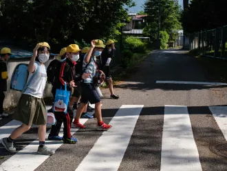 Children head to school in Japan, wearing masks to protect against COVID-19.
