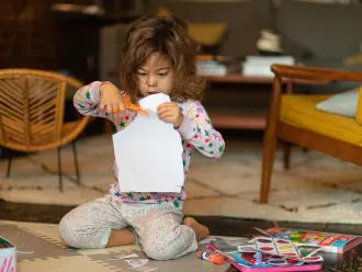 A little girl does crafts at home during COVID-19 lockdowns.