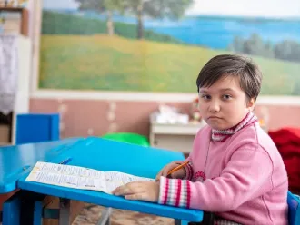 A girl sits in a classroom in Eastern Ukraine.