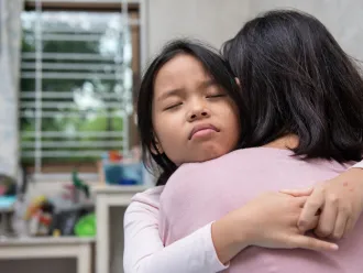 A girl hugs her mother.