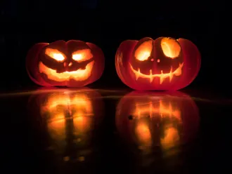 A pair of brightly lit jack o lanterns.