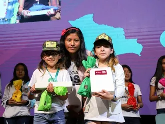 Girls receive awards at a tech event in Bolivia.