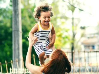Child playfully thrown in the air by mother